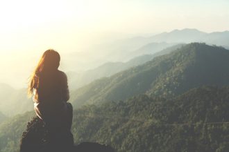 Mindful Travel - woman sitting on mountain