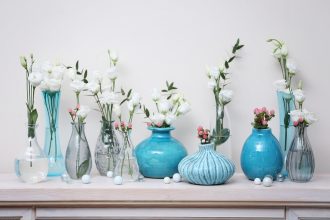 Fresh flowers in vases on mantelpiece