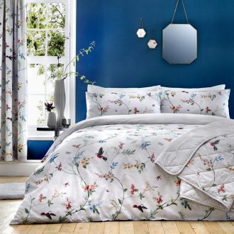 Blue painted wall with white flowery bedding