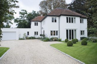 Large white detached house with gravel driveway